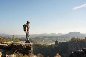 junge frau mit rucksack steht auf der alten deutschen burg im nationalpark sächsische schweiz foto