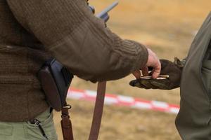 Männliches Training mit Pump-Action-Schrotflinte im Freien im Feld. foto