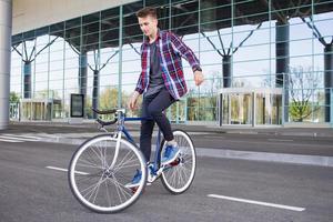 radfahrermann, der retro-fahrrad mit festem getriebe fährt. foto