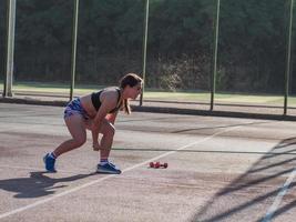 Junge starke Frau, die im Sommer im Freien trainiert, weibliche Profisportlerin macht Übungen im Park foto