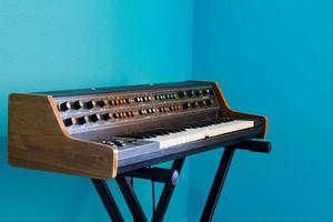 Alter Synthesizer mit farbenfrohen Schaltern auf blauem Hintergrund foto