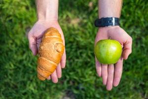 Männchen, das die Wahl zwischen gesundem und schädlichem Essen trifft. Ess- und Lifestyle-Konzept. foto