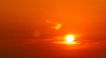 dramatischer roter und orangefarbener Himmel und abstrakter Hintergrund der Wolken. Flugzeug, das bei Sonnenuntergang in der Nähe der großen Sonne fliegt. Kunstbild des Himmels in der Abenddämmerung. abstrakter hintergrund des sonnenuntergangs. Verkehrsfluggesellschaft im Abendflug. foto