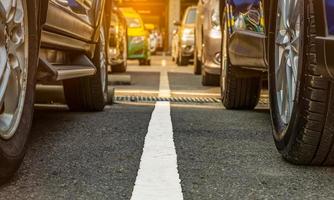 asphaltierter Parkplatz des Flughafens oder Einkaufszentrums. Pkw-Stellplatz zu vermieten. Nahaufnahmerad vieler Autos, die auf dem Parkplatz im Freien geparkt sind. Automobilindustrie. Pkw-Stellplatz. weltweiten Gebrauchtwagenmarkt foto