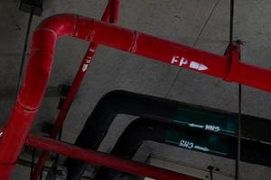 Sprinkleranlage mit roten Rohren, die von der Decke im Gebäude hängen. Brandbekämpfung. Brandschutz und Detektor. Hauptversorgungswasserleitung in der Feuerlöschanlage im Werk. foto
