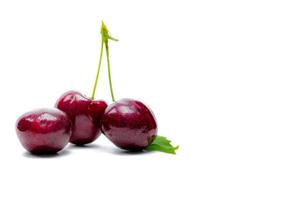 rote Kirsche mit Stiel und Blatt isoliert auf weißem Hintergrund. reife rote Süßkirsche. süße und saftige Bio-Kirsche. frisches obst für sommerdessert. Rohstoff für die Marmeladenindustrie. antioxidative Nahrung. foto