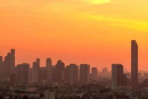 Luftverschmutzung. smog und feinstaub der pm2.5 bedeckten stadt morgens mit orangefarbenem sonnenaufgangshimmel. stadtbild mit verschmutzter luft. schmutzige Umgebung. städtischer giftiger Staub. ungesunde Luft. städtisches ungesundes Leben.