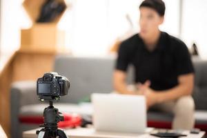 online-verkaufs- und social-media-marketing-konzept, junger asiatischer mann, der mit der kamera arbeitet, um live-streaming zu verkaufen, um ein produkt zu verkaufen und paket zu zeigen, um zu überprüfen, cyberspace und blog-shop zu übertragen foto
