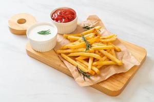 Pommes Frites mit Sauerrahm und Ketchup foto