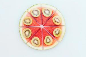 leckeres Sommerdessert. Wassermelonenpizza mit Kiwischeiben lokalisiert über weißem Hintergrund. Food-Art-Konzept. süßer Snack. frisches Obstgericht der Saison foto