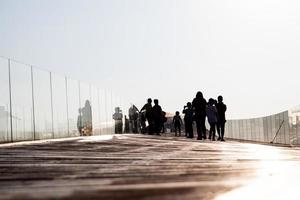 Silhouettenmenschen auf der alten Holzbootbrücke. foto