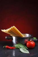 Spaghetti in einer Pfanne mit Tomaten und Basilikum