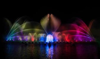 der bunte Springbrunnen tanzt zur Feier des Jahres mit dunklem Nachthimmelhintergrund. foto