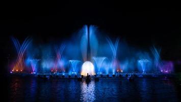 der bunte Springbrunnen tanzt zur Feier des Jahres mit dunklem Nachthimmelhintergrund. foto