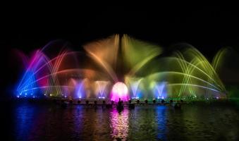 der bunte Springbrunnen tanzt zur Feier des Jahres mit dunklem Nachthimmelhintergrund. foto