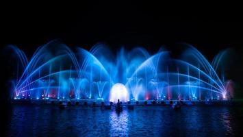 der bunte Springbrunnen tanzt zur Feier des Jahres mit dunklem Nachthimmelhintergrund. foto