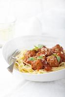 Fleischbällchen in Tomatensauce und frischem Basilikum mit Spaghetti foto