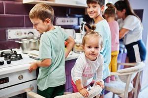 mutter mit kindern, die in der küche kochen, glückliche kindermomente. foto