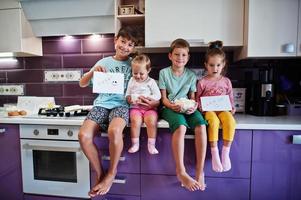 Kinder kochen in der Küche, glückliche Kindermomente. vier Kinder, große Familie. foto