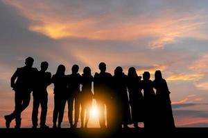 Silhouette von Geschäftsleuten Feier Erfolg Glück Team stehend mit verschränkten Armen bei Sonnenuntergang Abendhimmel Hintergrund foto