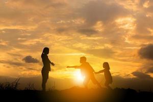 silhouette von bruder und schwester lief zur mutter bei sonnenuntergang hintergrund, glückliches mutter- und kindkonzept. foto