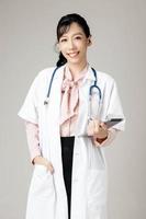 Porträt einer attraktiven jungen Ärztin im weißen Kittel. foto
