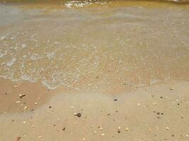 Sand mit Wellen und Felsen foto