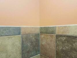 braune und graue Fliesen und pfirsichfarbene Wand in der Badezimmerecke foto