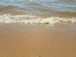 Sand mit Wellen und Felsen foto