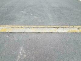 erhöhter asphalt- oder pflasterweg mit gelbem bordstein oder rampe foto