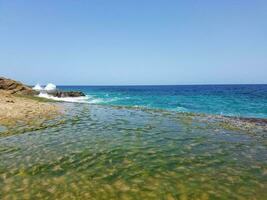 Felsen, Sand und Wellen am Strand in Puerto Rico foto