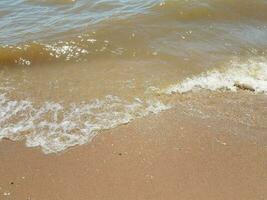 Sand mit Wellen und Felsen foto