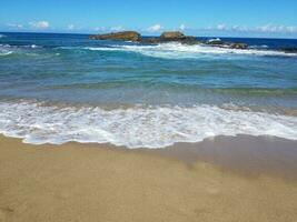 Sand und Wellen am Strand in Isabela, Puerto Rico mit Kreuz foto