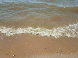 Sand mit Wellen und Felsen foto