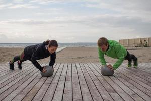 gruppe junger leute, die im freien trainieren, läuferübungen, meer- oder flusshintergrund foto