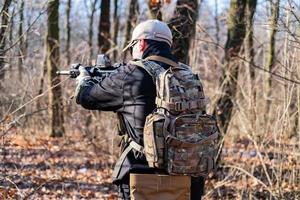 Männchen aus privater Militärfirma mit Gewehr im Wald foto