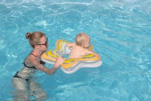 glückliche familie, die eine gute zeit im blauen schwimmbad hat foto