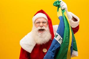 der weihnachtsmann ist ein fan von brasilien. Weihnachtsmann-Anhänger des brasilianischen Teams. sportliche Meisterschaft. weihnachtsmann, der die brasilianische flagge hält. Fußballspiel. foto