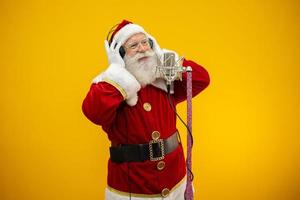 der weihnachtsmann singt oder spricht in einem studiomikrofon. frohe Weihnachten. Sender. Ansager. Förderung. weihnachtsmusikkonzept. foto