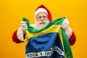 der weihnachtsmann ist ein fan von brasilien. Weihnachtsmann-Anhänger des brasilianischen Teams. sportliche Meisterschaft. weihnachtsmann, der die brasilianische flagge hält. Fußballspiel. foto