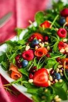 gesunder Salat mit Rucola, Spinat, Räucherlachs und Beeren