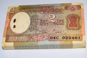 alte zwei rupie-scheine kombiniert auf dem tisch, indisches geld auf dem rotierenden tisch. alte indische Banknoten auf einem rotierenden Tisch, indische Währung auf dem Tisch foto