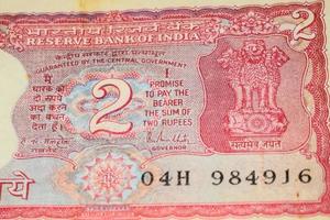 alte zwei rupie-scheine kombiniert auf dem tisch, indisches geld auf dem rotierenden tisch. alte indische Banknoten auf einem rotierenden Tisch, indische Währung auf dem Tisch foto