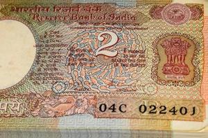 alte zwei rupie-scheine kombiniert auf dem tisch, indisches geld auf dem rotierenden tisch. alte indische Banknoten auf einem rotierenden Tisch, indische Währung auf dem Tisch foto