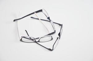 Viele Brillen zur Sehkorrektur liegen isoliert auf weißem Hintergrund. Optik, Augenuntersuchung, Augenheilkunde. foto