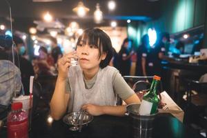 porträt glückliches lächeln junge erwachsene asiatische frau jubeln mit soju im koreanischen restaurant. foto