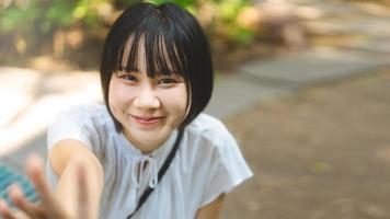 porträt einer glücklichen lächelnden asiatischen frau mit kurzen haaren und einer aussehenden kamera.