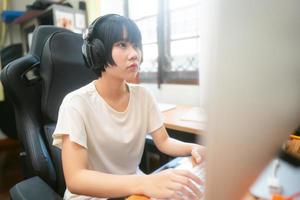 junge erwachsene asiatische frau bleibt zu hause und nutzt den computer für das internet online. foto