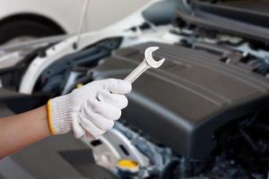 Hand des Automechanikers mit Schraubenschlüssel foto