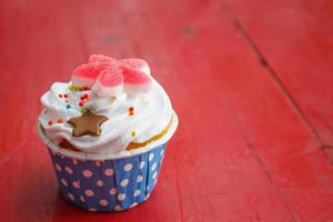 Leckere Cupcakes mit Buttercreme, auf farbigem Holzhintergrund foto